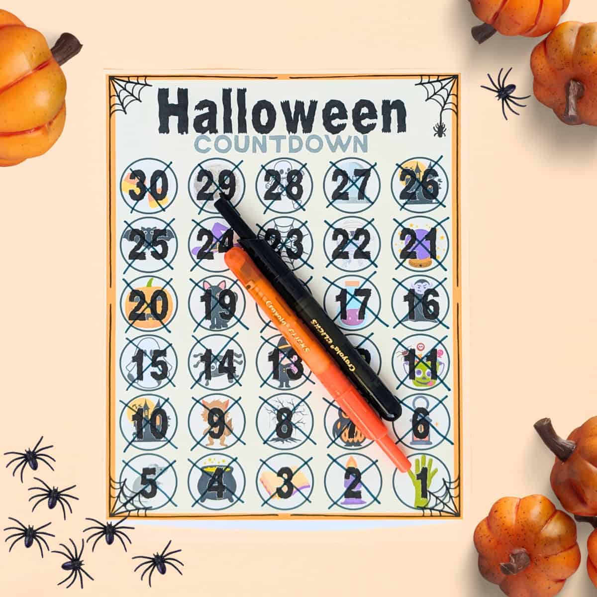 Flatlay image of the Halloween countdown calendar with the days crossed off and fun pumpkin and spider decorations. 