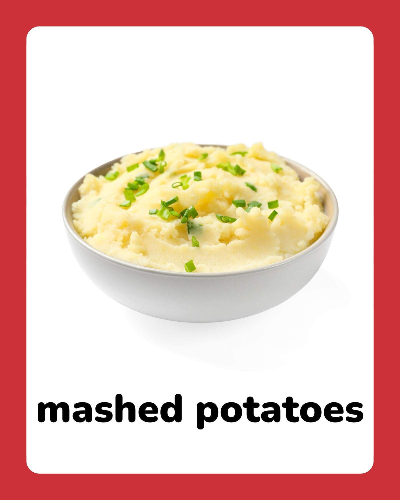 Bowl of creamy mashed potatoes garnished with chopped green herbs centered on a white card with red border.