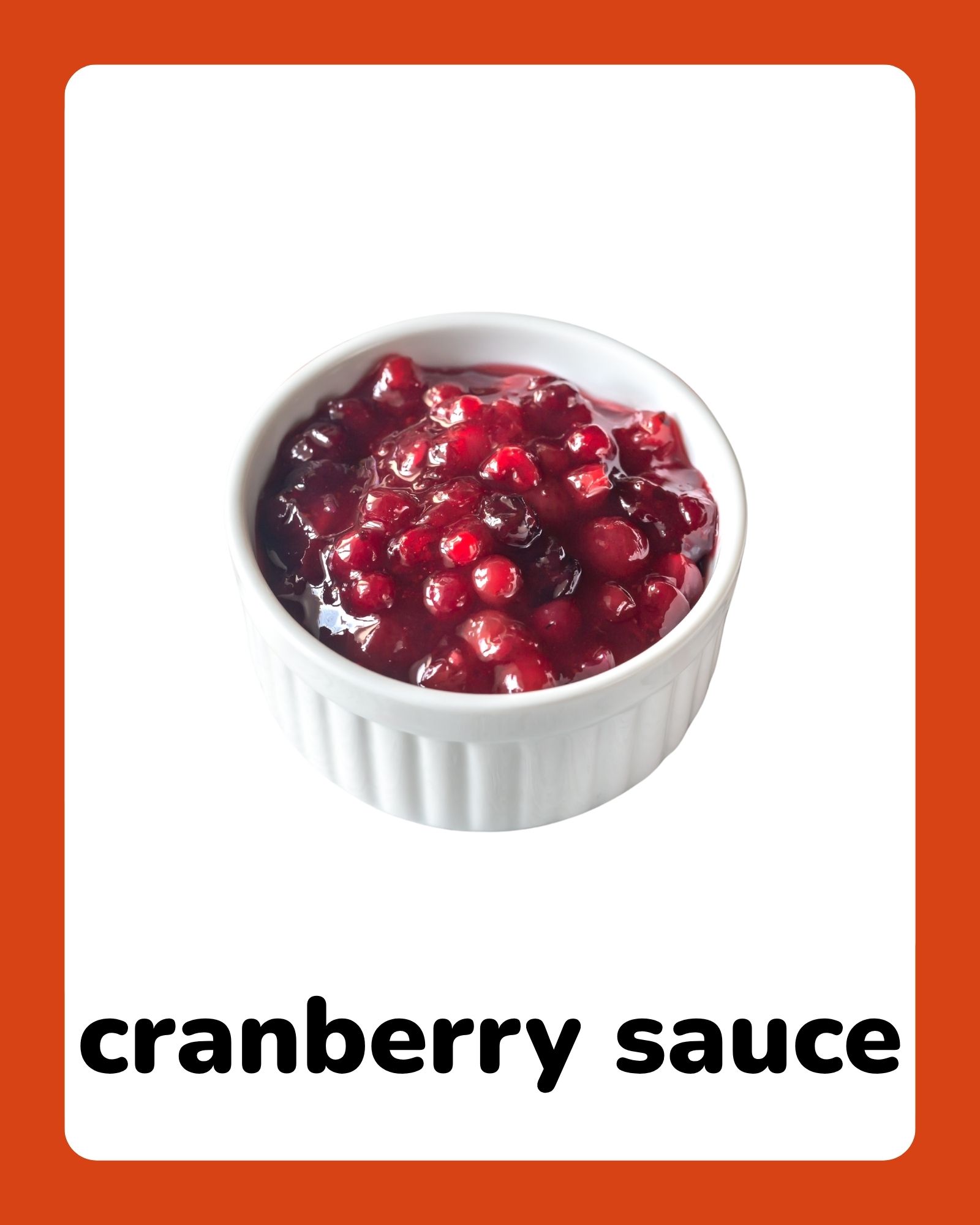 White ramekin filled with glossy red cranberry sauce centered on a white card with wide orange borders.